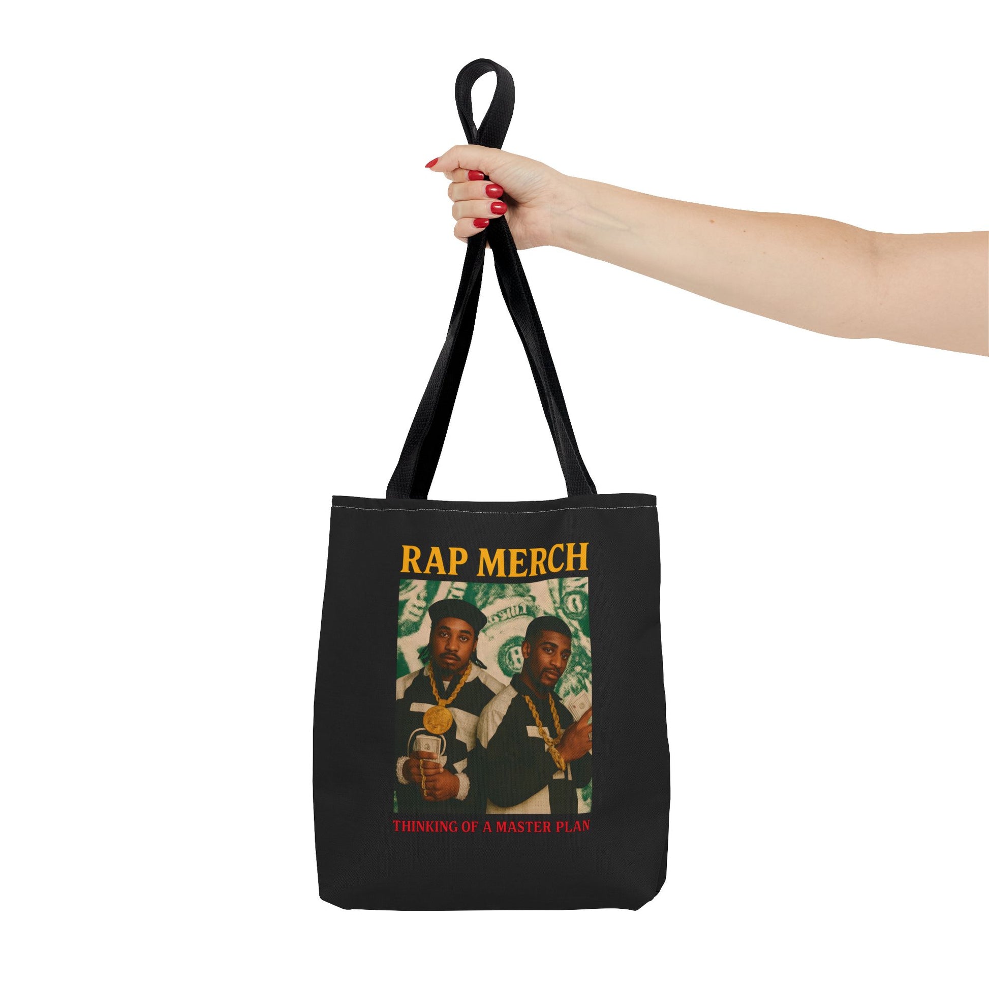 Black tote bag with 'Rap Merch' design held by a hand on a white background
