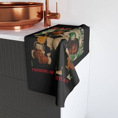 Towel with graphic design draped over a sink in a kitchen setting