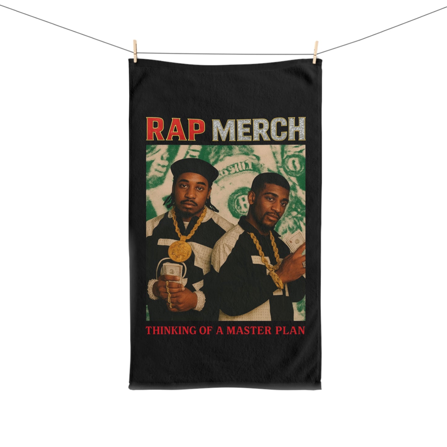 Towel with graphic of two people holding money and text 'Rap Merch: Thinking of a Master Plan' on a black background.