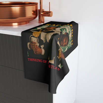 Towel with a graphic design hanging over a sink in a bathroom setting