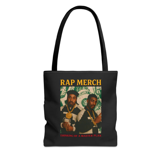 Black tote bag with 'Rap Merch' design featuring two individuals and money-themed graphics on a white background.